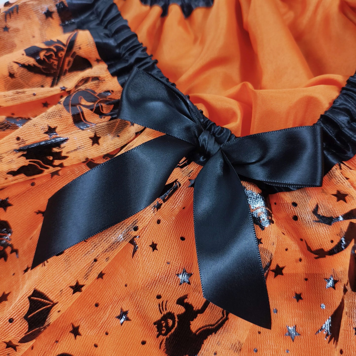 Halloween Adults Tulle Skirt Adorned with bats pumpkins stars this orange tulle skirt has a black bow waist  trim